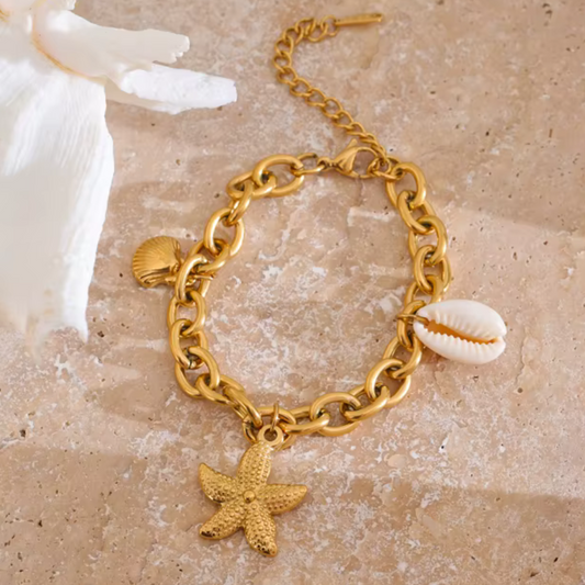 Gold charm bracelet with starfish and ocean shell pendants