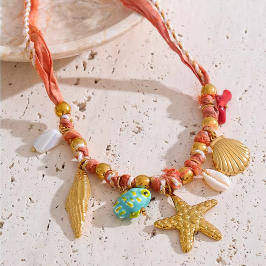 Handmade tropical red rope necklace with 18K gold-plated starfish, shell, and conch charms – resin, ceramic, and natural shell details
